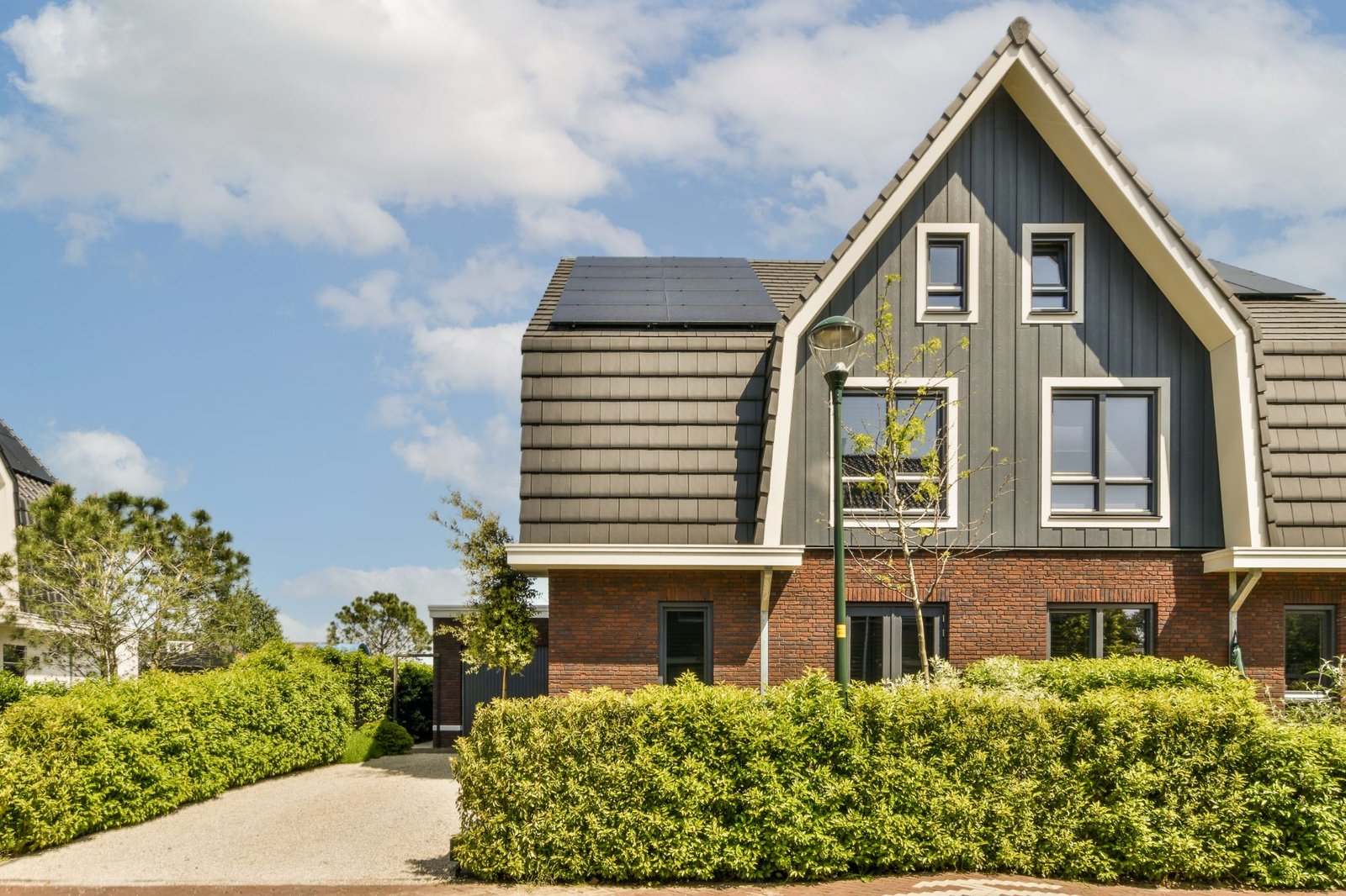 a-brick-house-with-a-grey-roof-and-a-driveway-BLSGHB6.jpg